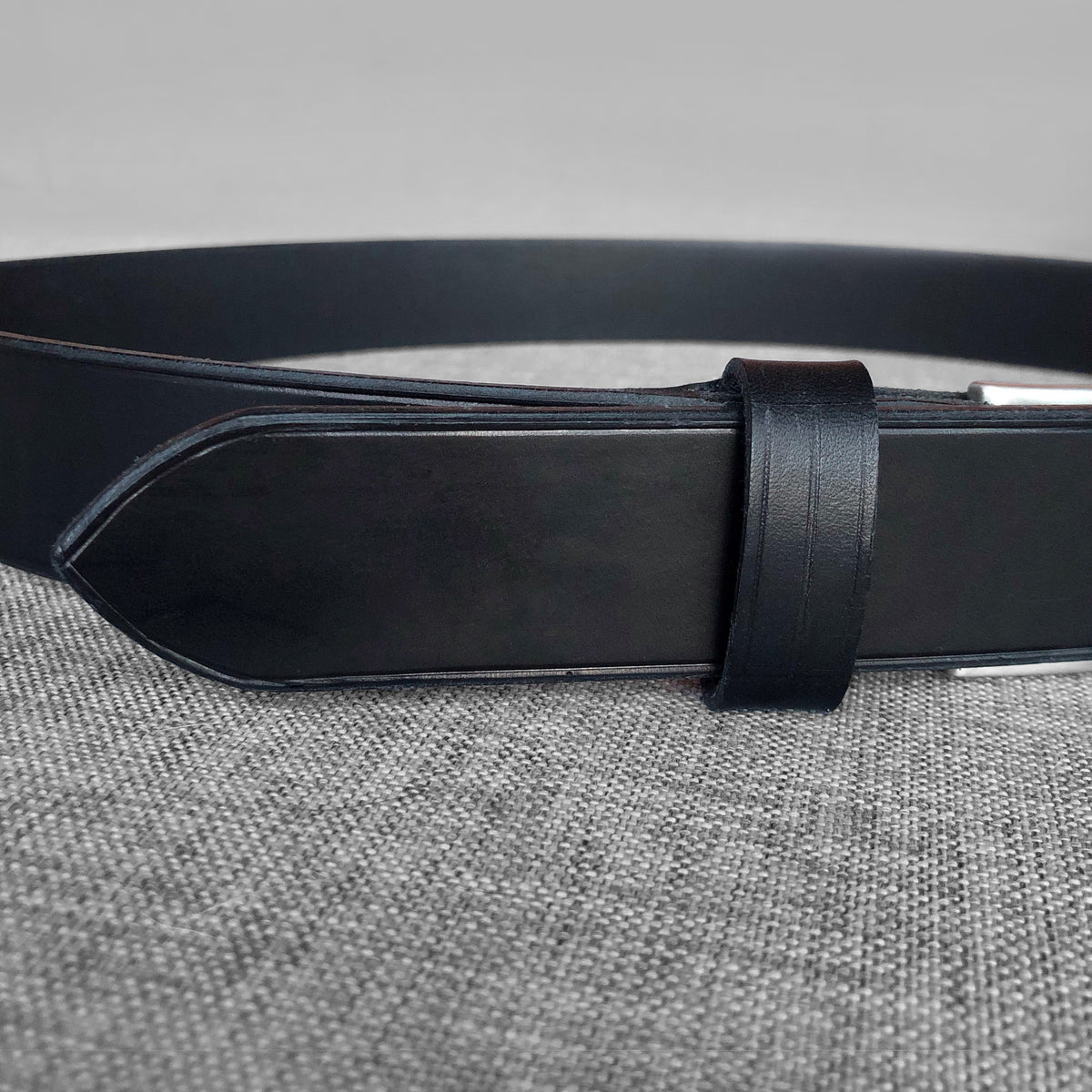 Ceinture Louis en cuir noir, gros plan sur le passant et l'extremite pointue