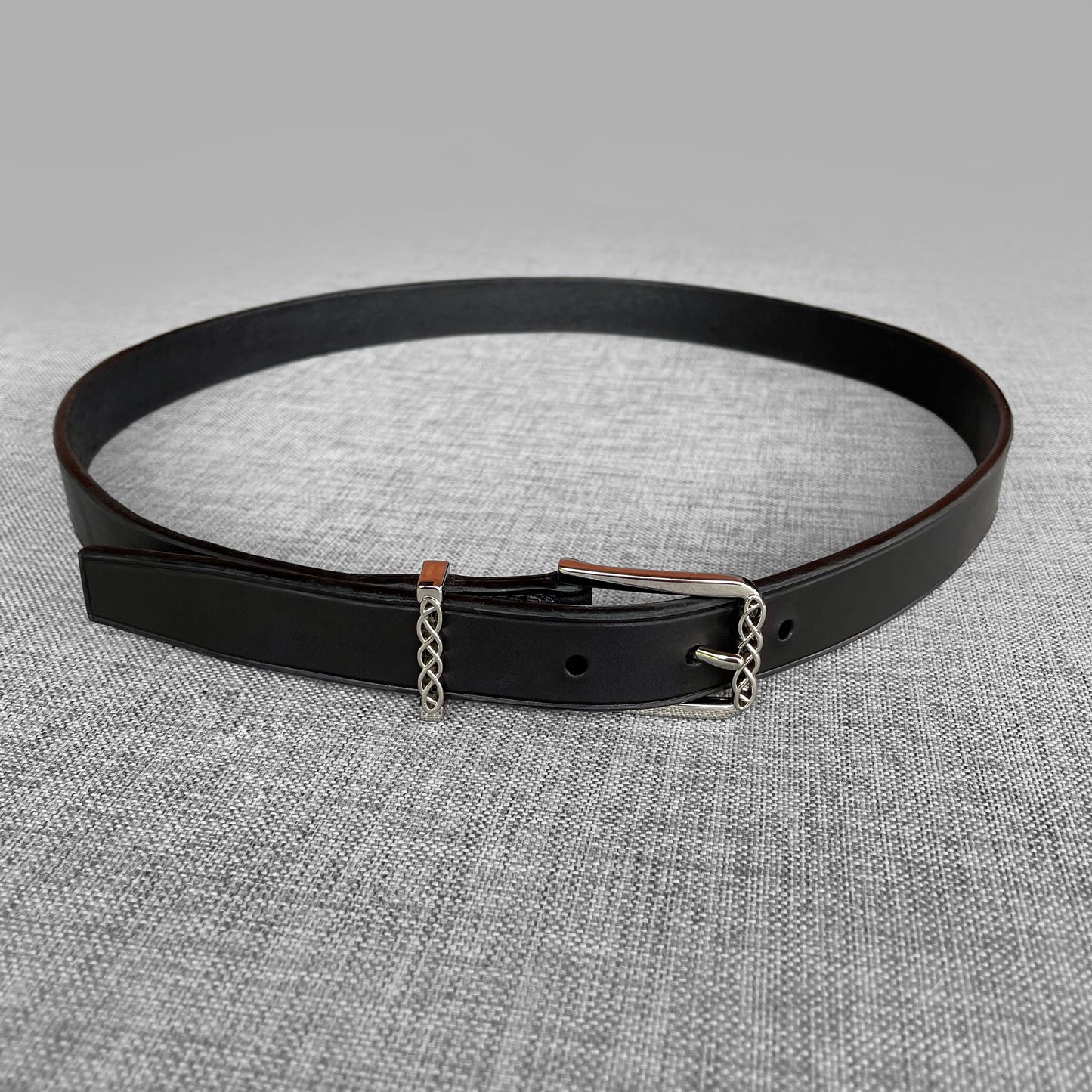 Ceinture en cuir noir enroulee avec boucle argentee a motif de chaine