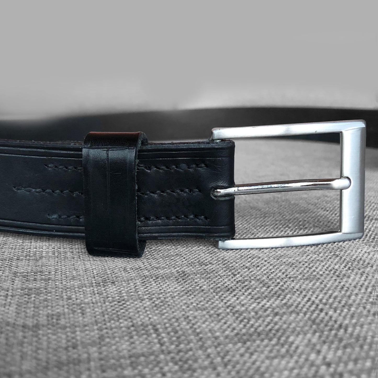 Ceinture en cuir noir avec boucle argentee carree, gros plan
