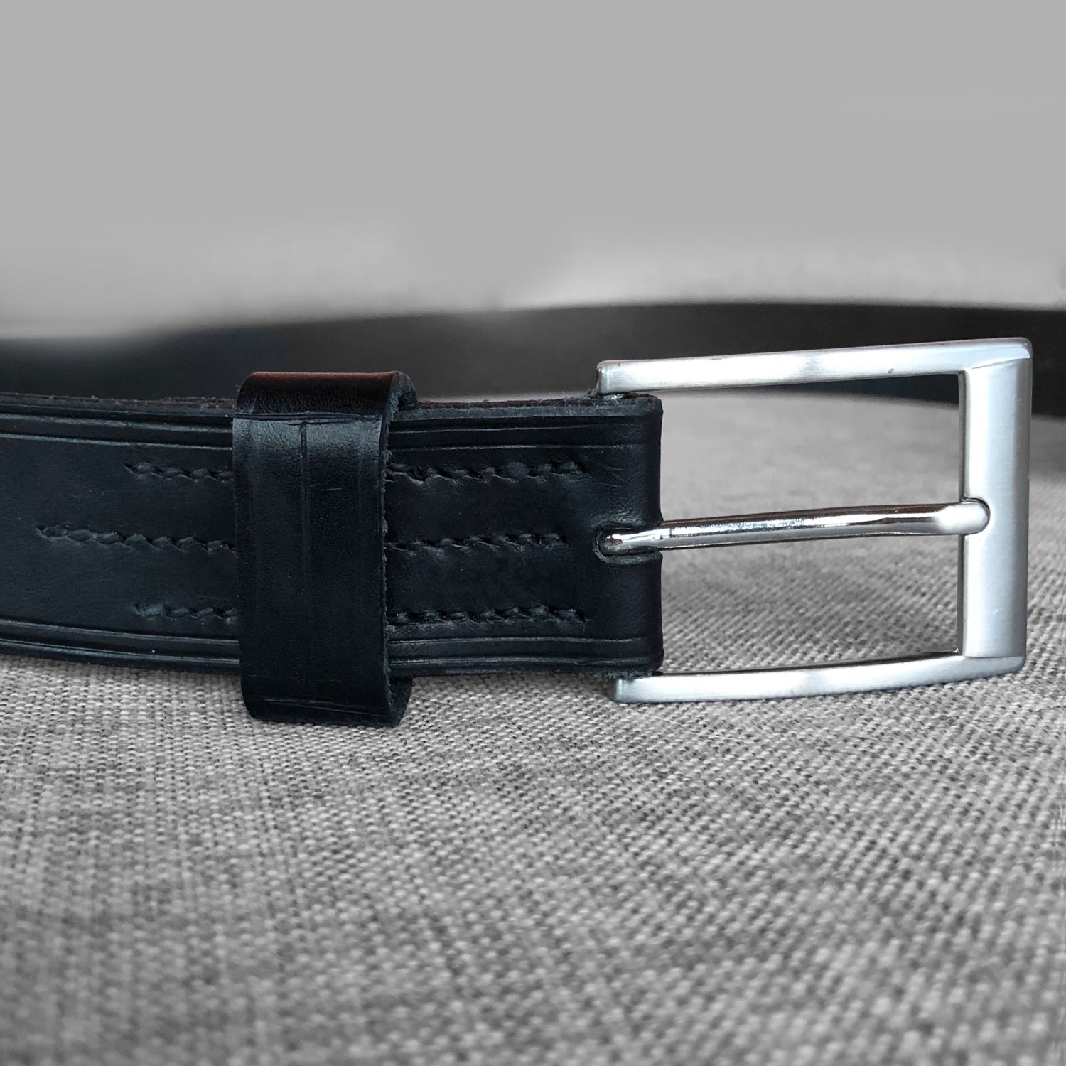 Ceinture en cuir noir avec boucle argentee carree, gros plan