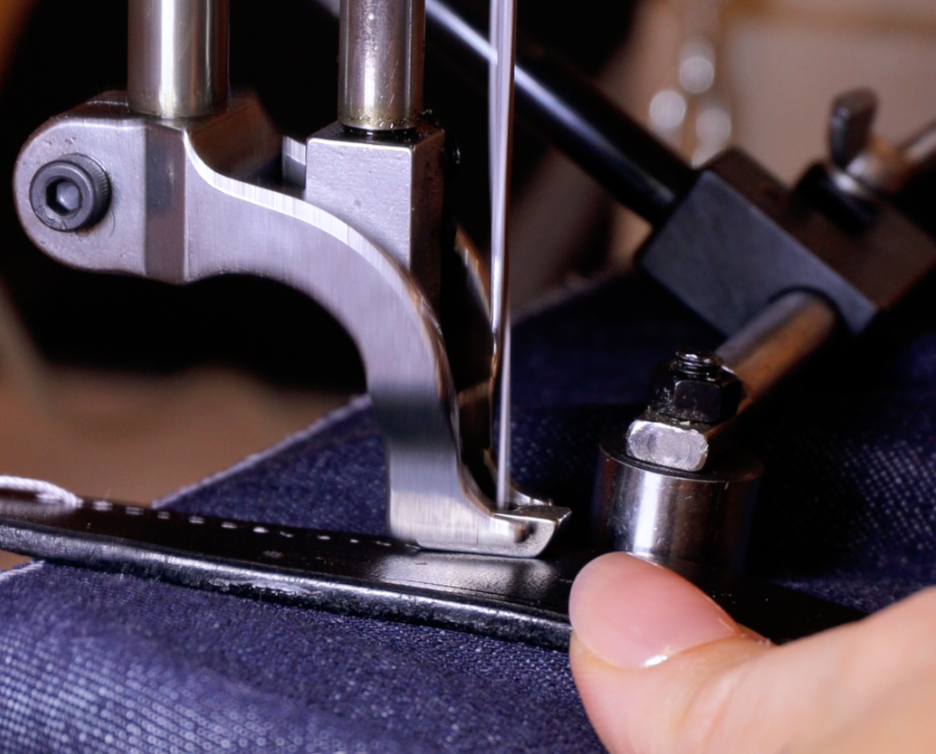 Couture à la machine d'une anse en cuir sur un sac en jeans, façonné à la main à l'atelier Ruffieux Création