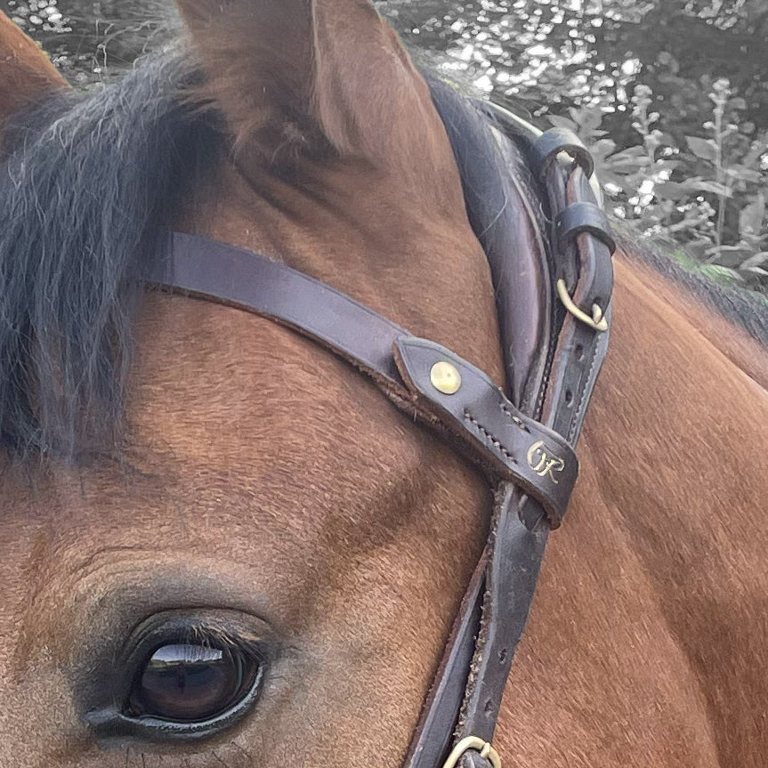 Frontal double en cuir marron sur bride de cheval, gros plan sur la couture et la boucle, fermeture à vis, sellerie, sur-mesure Ruffieux Création