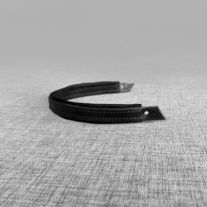 Detail de l'extremite d'un frontal double en cuir noir avec bouton pression