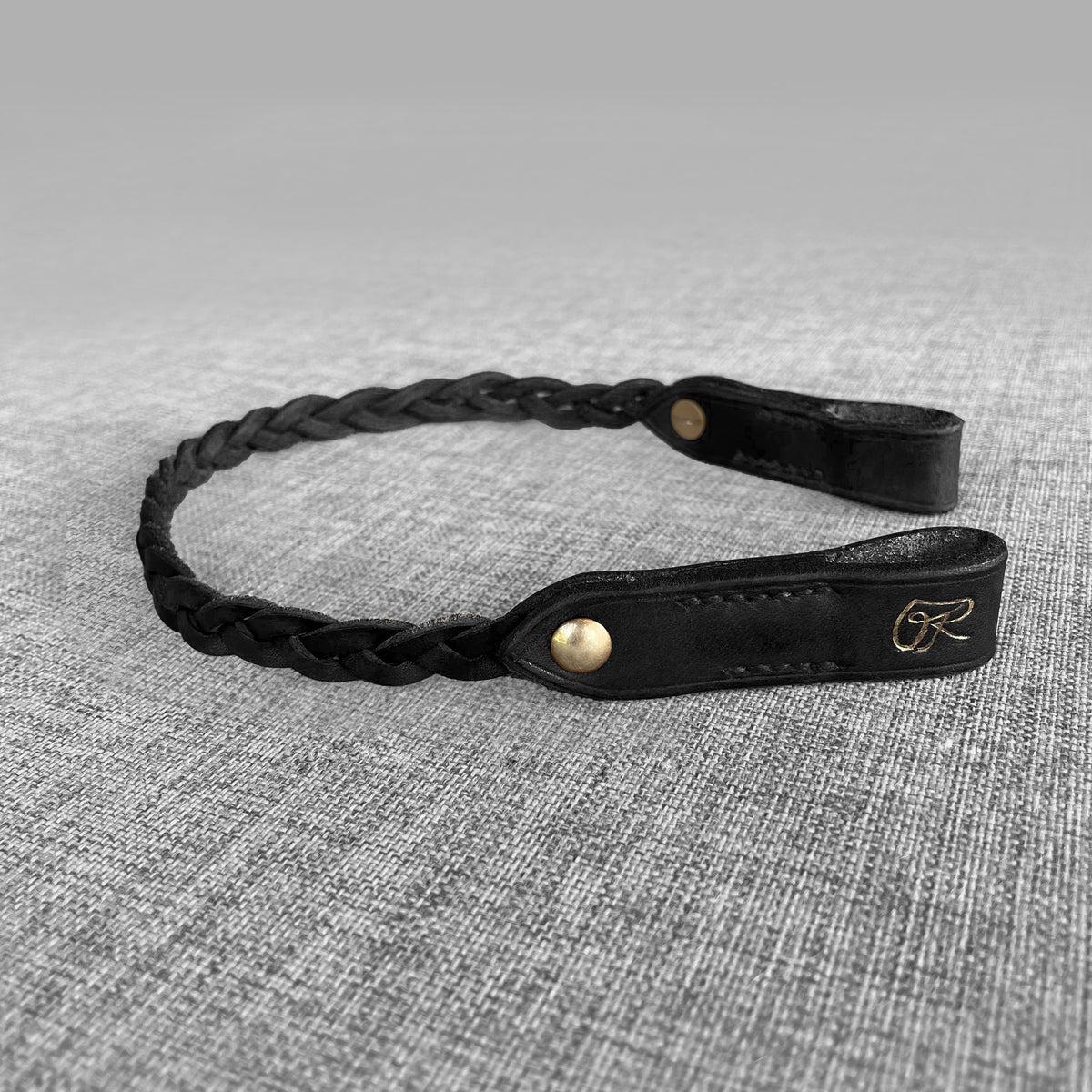 Frontal tresse en cuir noir avec bouton pression et logo Ruffieux Creation dore