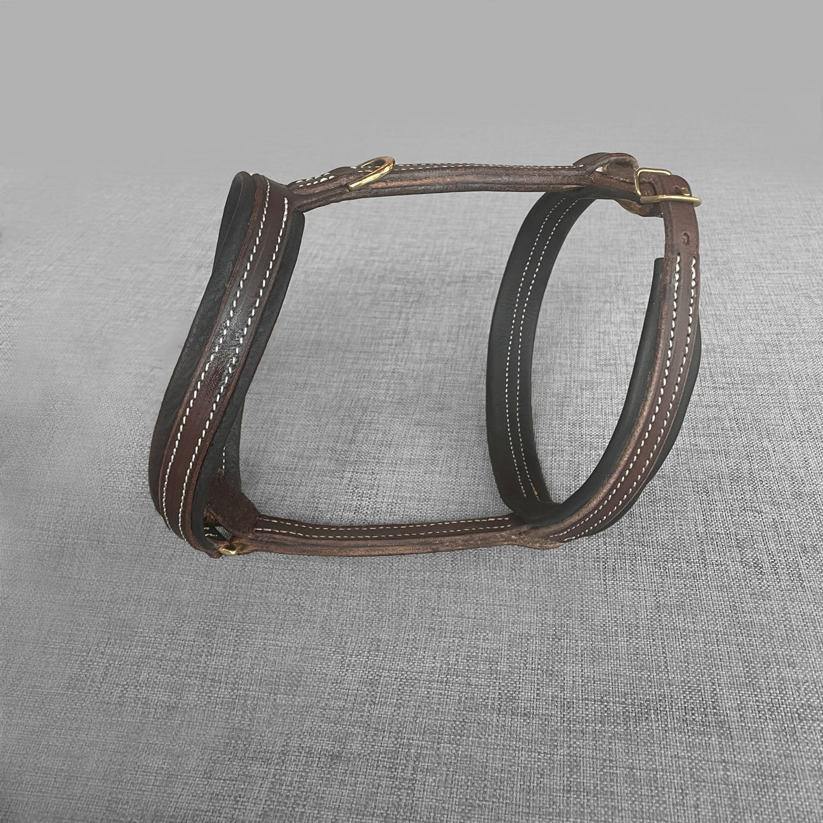 Harnais pour chien en cuir brun avec boucles dorees, pose a plat