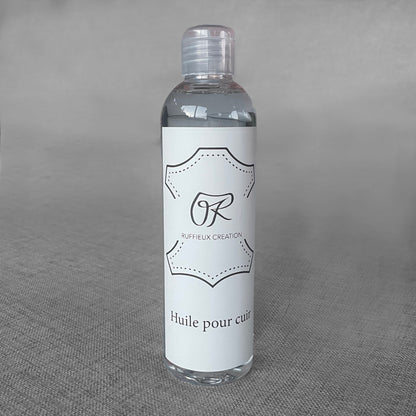Flacon d'huile pour cuir Ruffieux Creation pose sur un fond gris