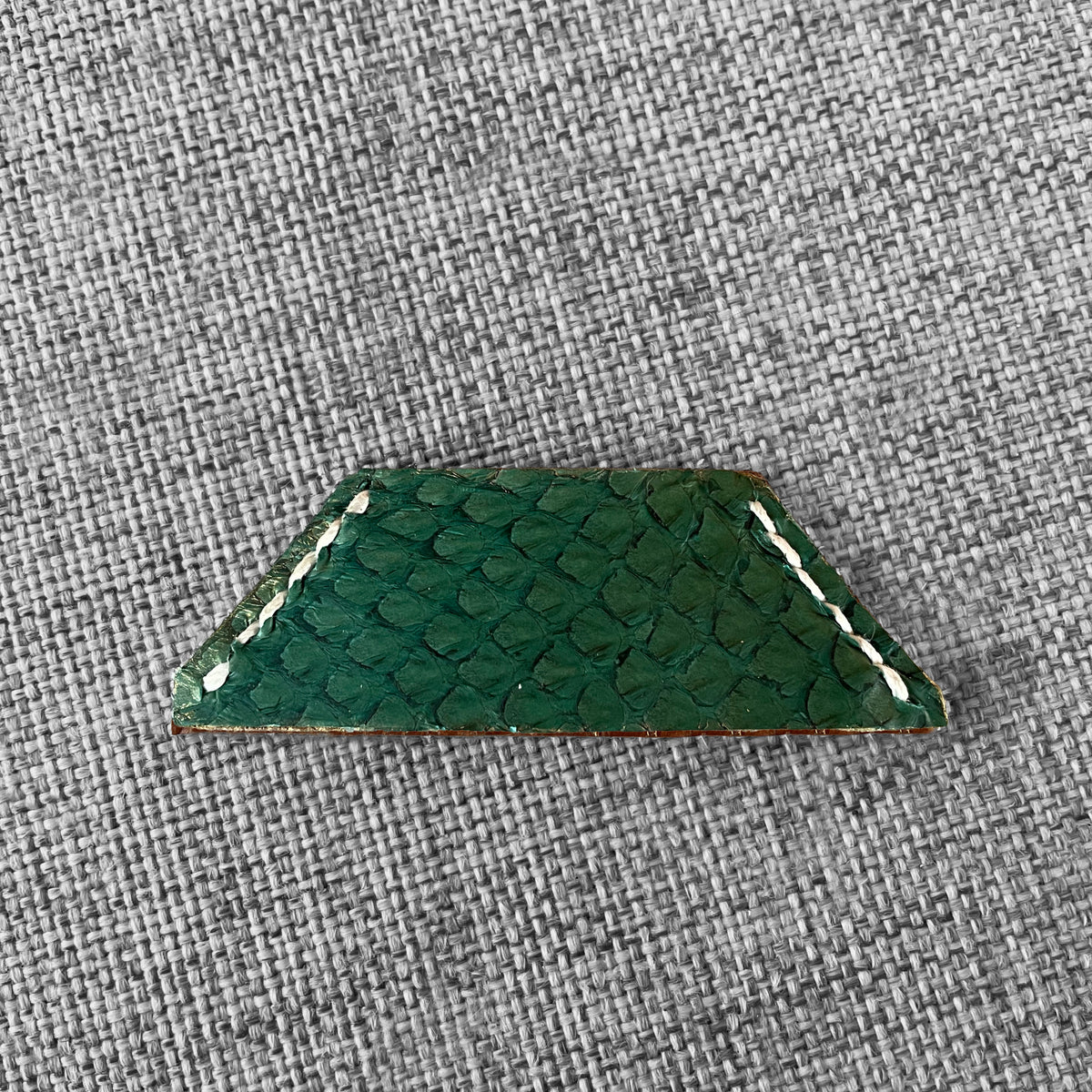 Marque-page en cuir vert a motif ecailles avec surpiqure blanche, vue rapprochee