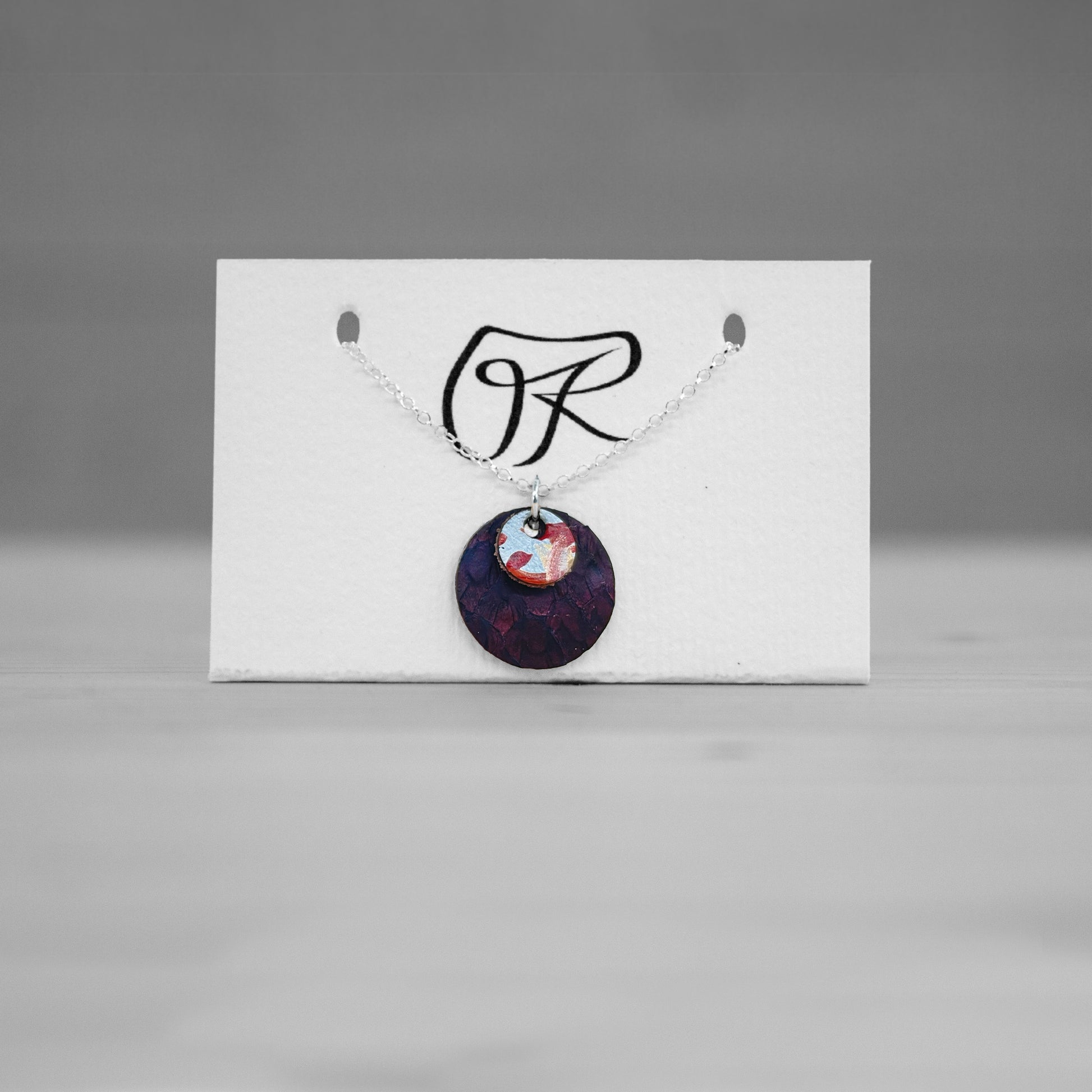 Pendentif rond en cuir bordeaux sur carte de presentation, bijou cuir Ruffieux Creation
