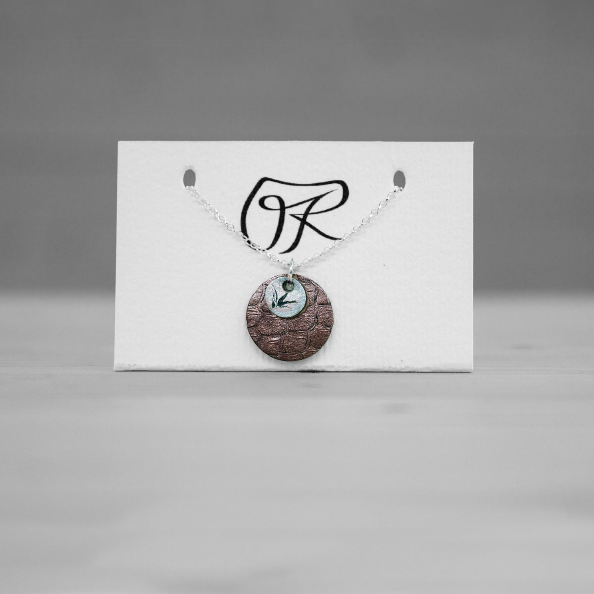 Pendentif rond en cuir cuivre texture sur carte de presentation, bijou cuir Ruffieux Creation