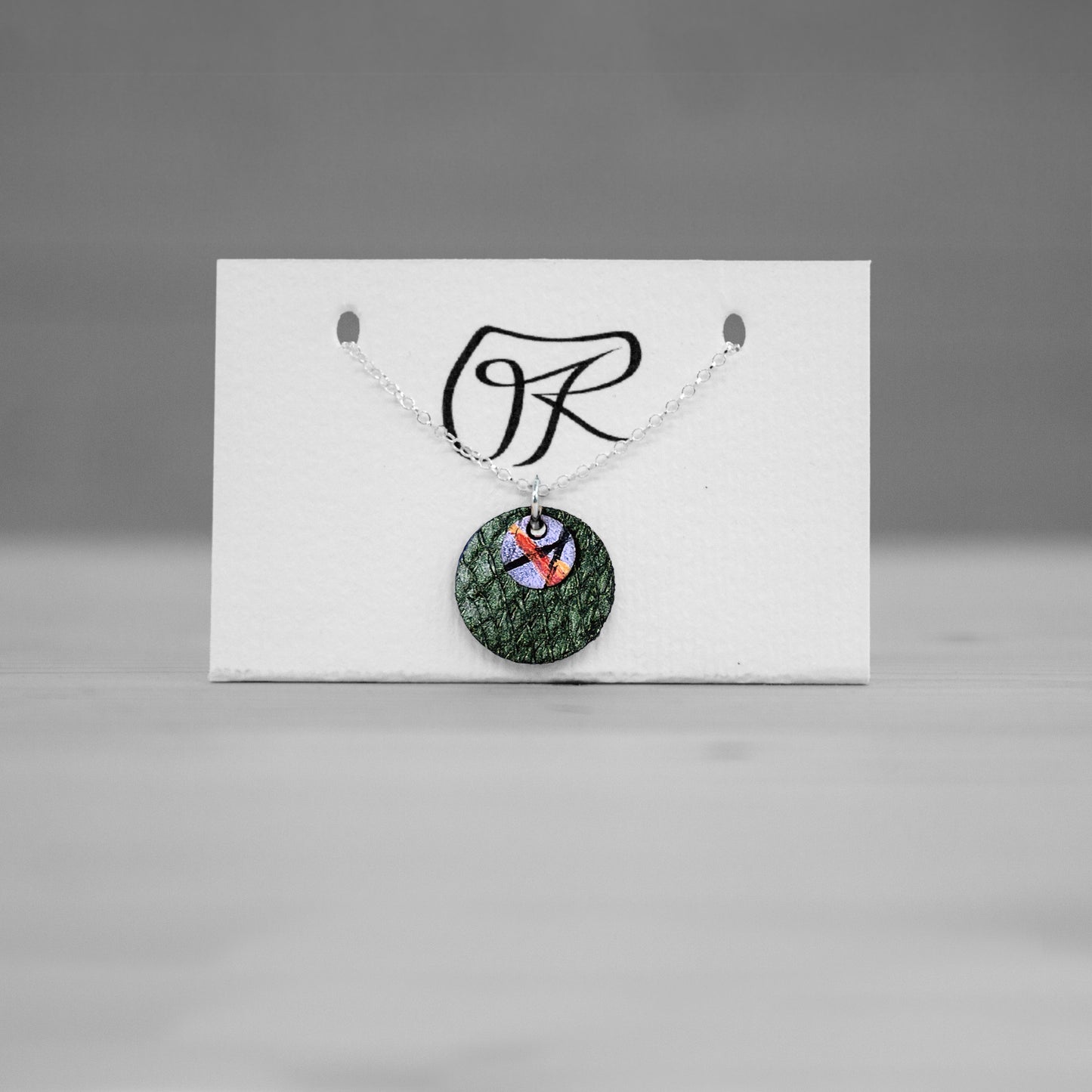 Pendentif rond en cuir vert sur carte de presentation, bijou cuir Ruffieux Creation