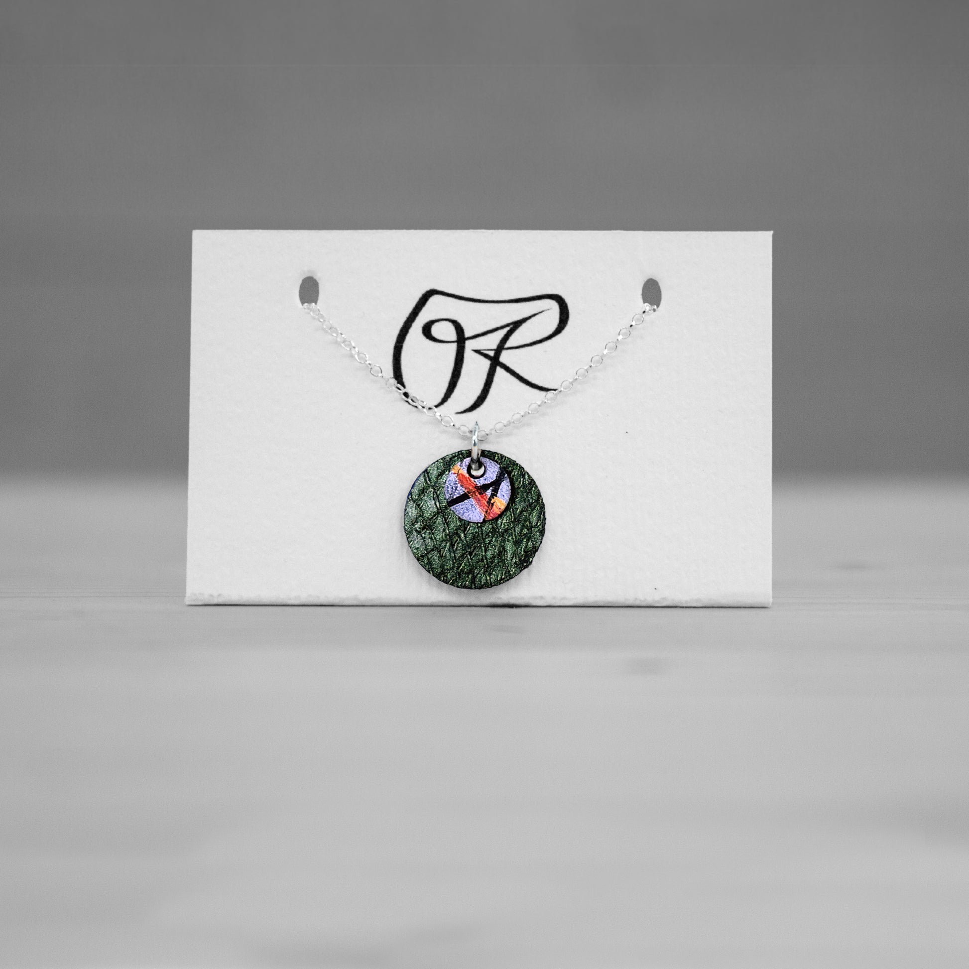 Pendentif rond en cuir vert sur carte de presentation, bijou cuir Ruffieux Creation