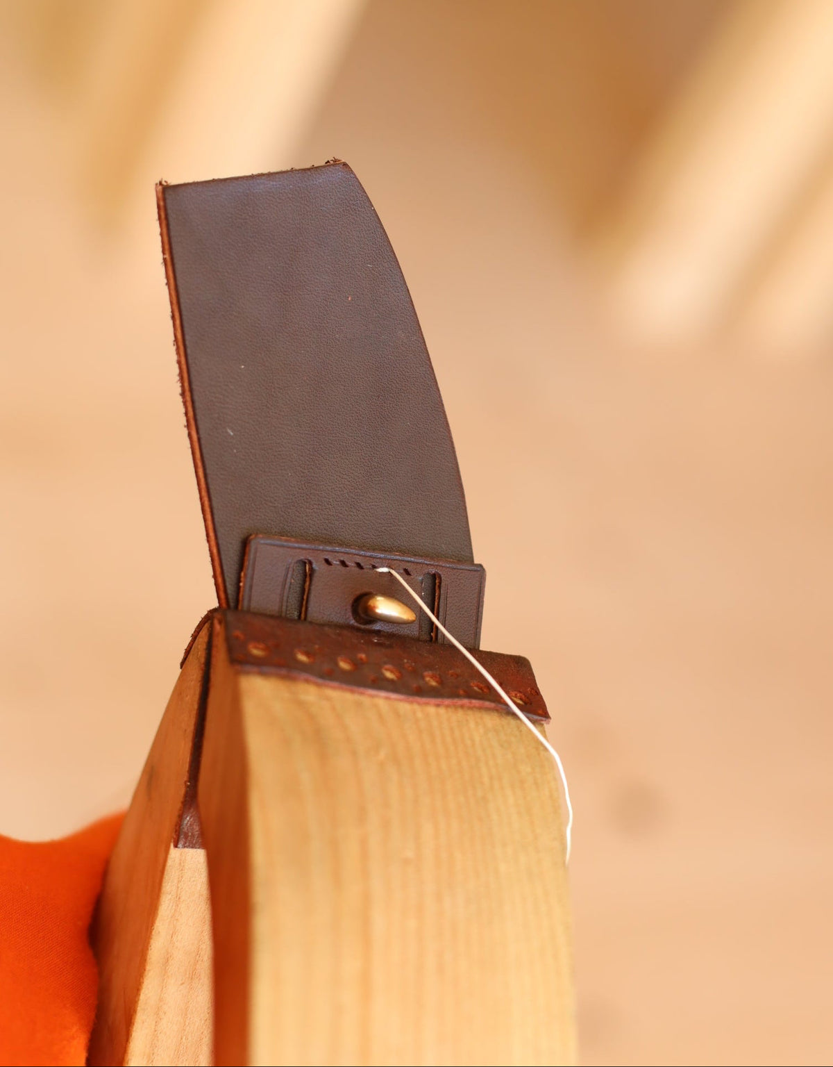 Point de sellier cousu a la main sur une piece de cuir, technique de couture traditionnelle a l'atelier Ruffieux Creation