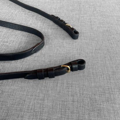 Renes de dressage en cuir noir avec mousquetons dores, vue d'ensemble