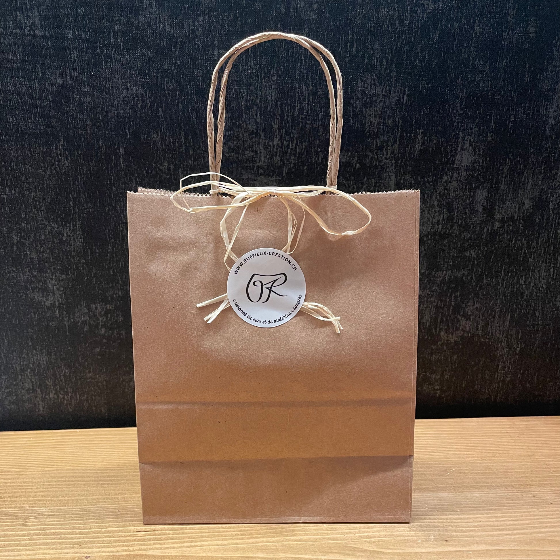 Sac cadeau en papier kraft avec anses en raphia et etiquette ronde Ruffieux Creation, vue rapprochee